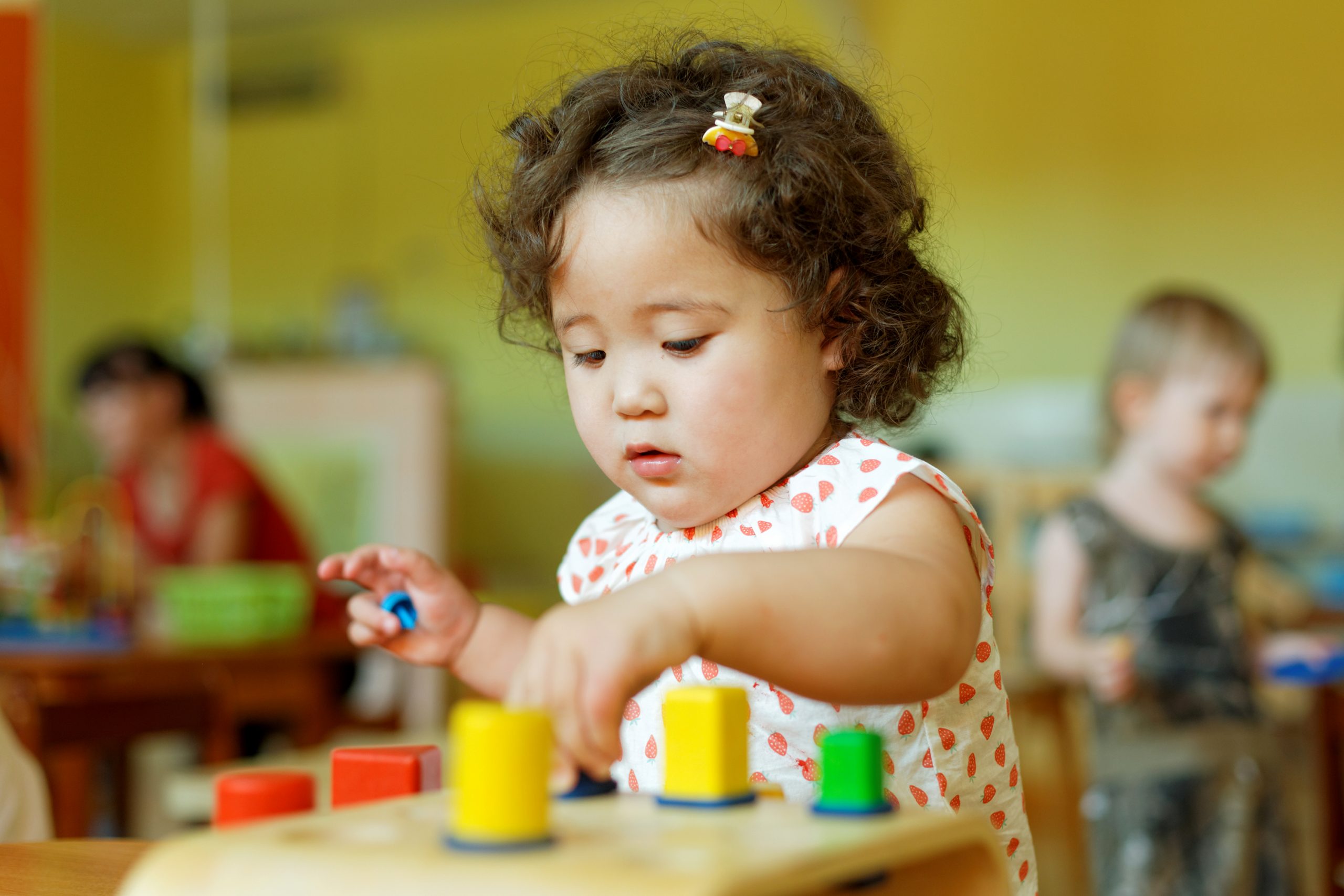 kazakh curly little girl playing in kids development center