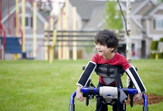 Boy in walker in front of playground