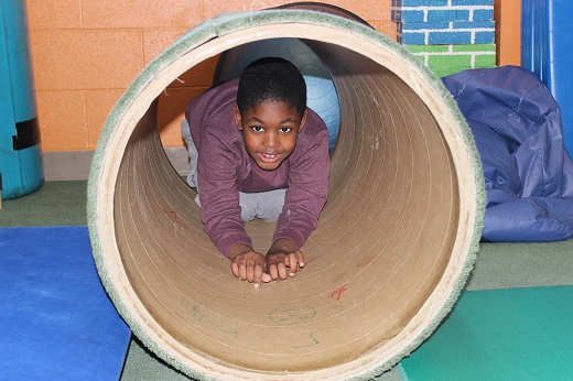 OT Center Young Boy playing in tunnel toy