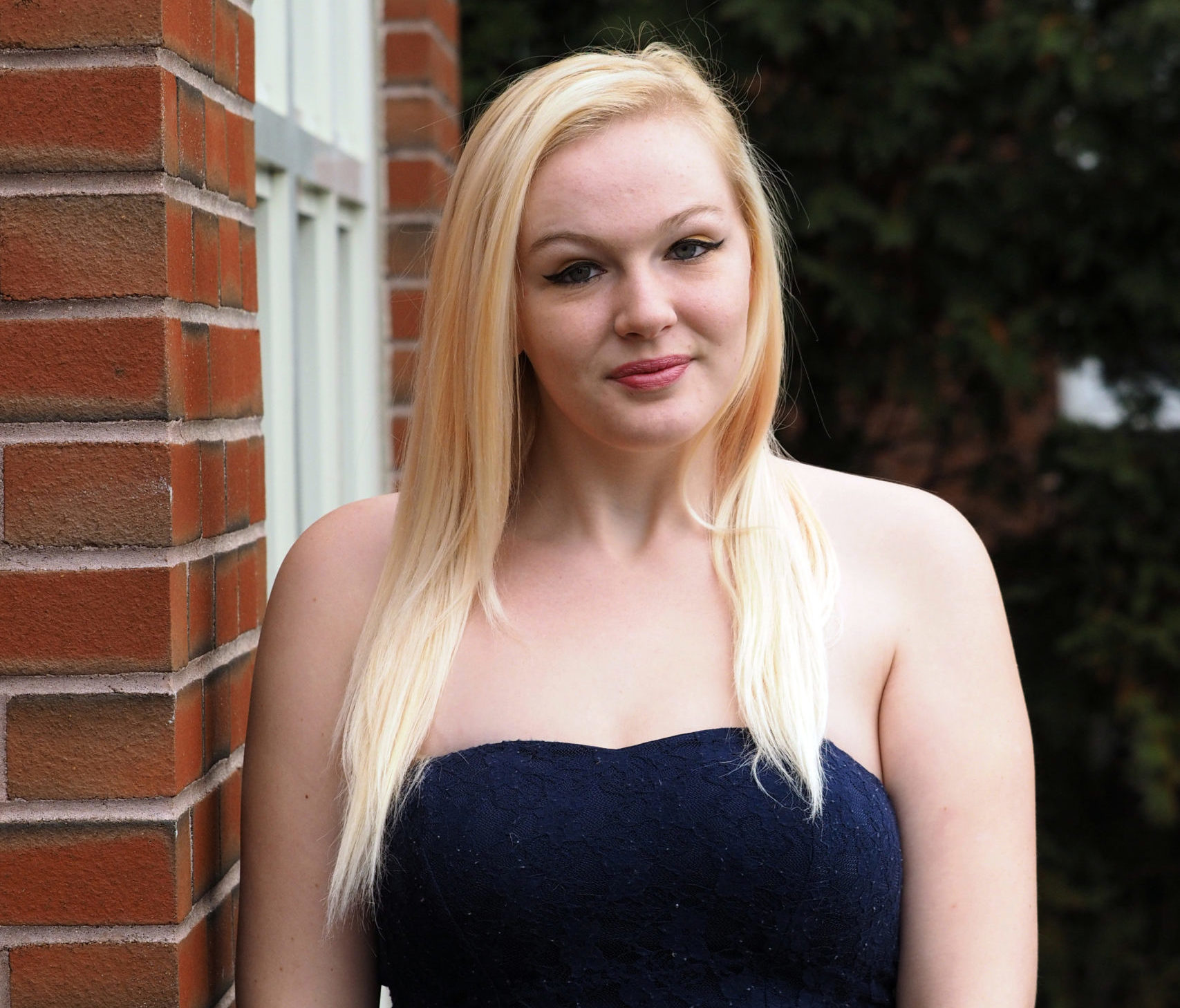 image of Tessa Santor standing against a brick building