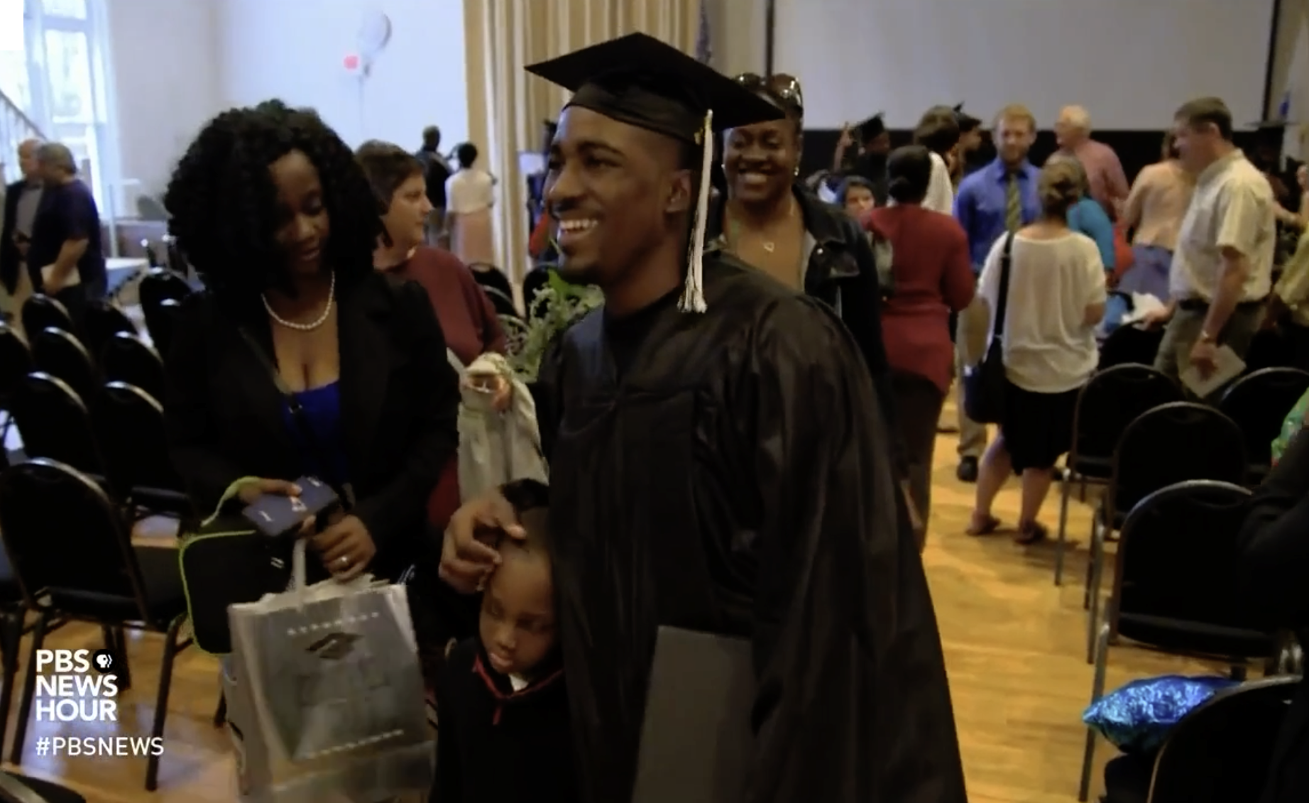 picture of a student in a graduation gown in a crowd of people