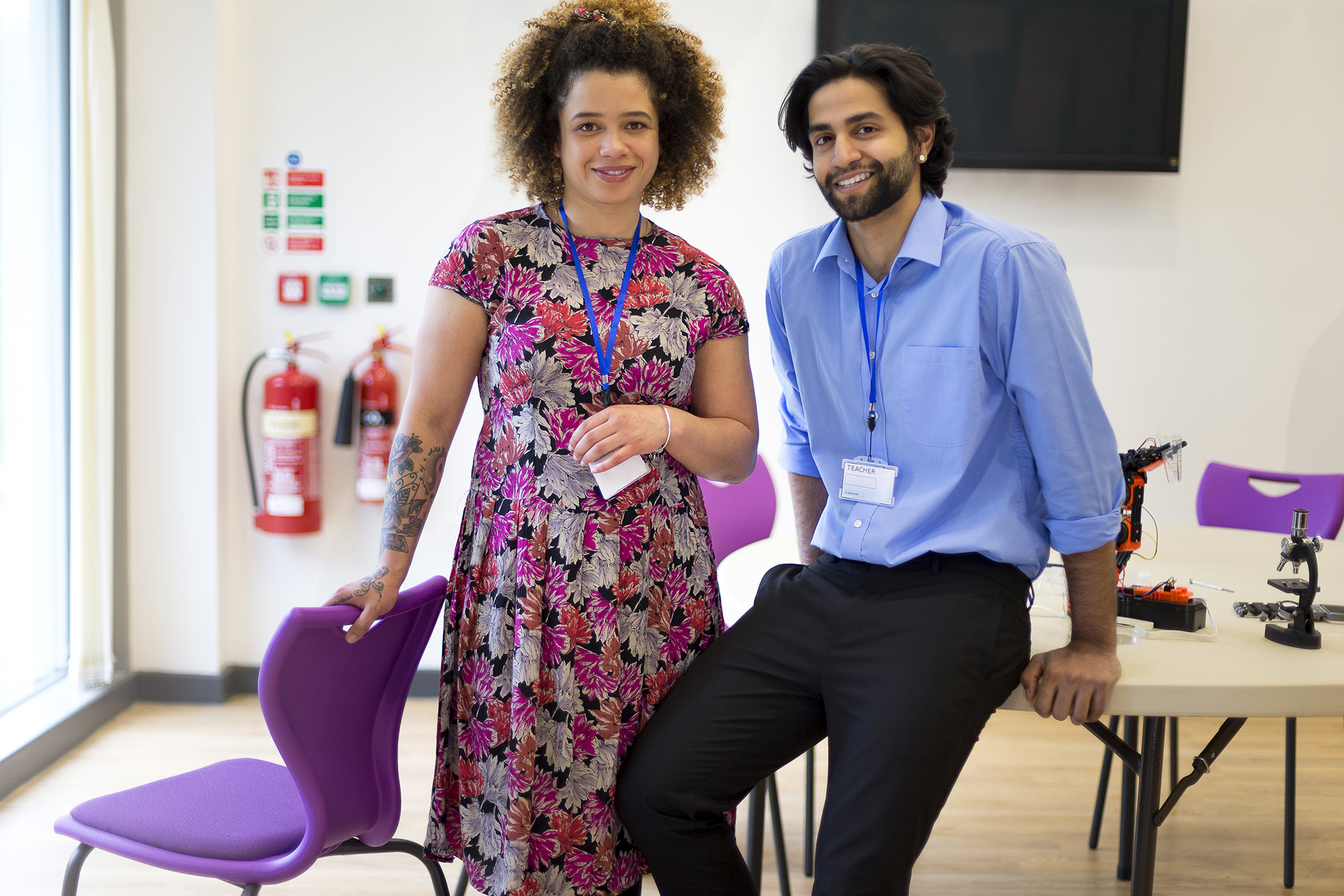 two teachers smiling at the camera in a classroom