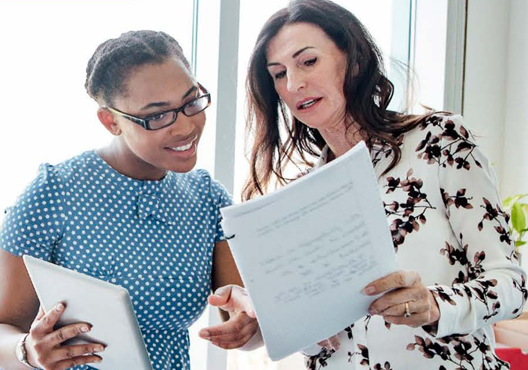 Black and Hispanic teachers consulting over files